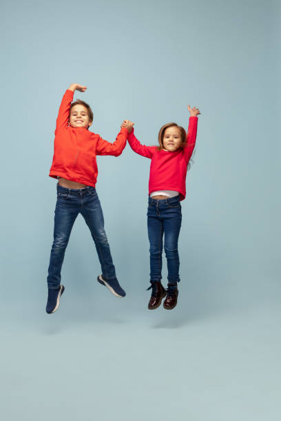 istock Happy children isolated on blue studio background. Look happy, cheerful, sincere. Copyspace. Childhood, education, emotions concept 1298288389