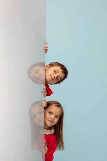 istock Happy children isolated on blue studio background. Look happy, cheerful, sincere. Copyspace. Childhood, education, emotions concept 1298288407