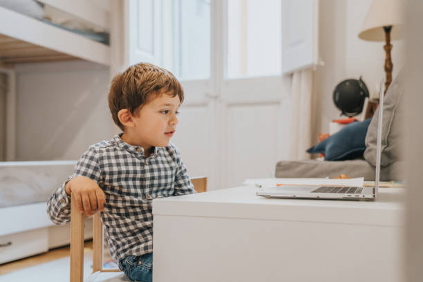istock Boy attending to online school class. 1298290456