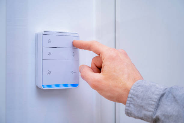 Smart Home Automation Finger pressing on the button of a smart home hub which controls the lights, thermostat and other electronics in the home of the future. doorbell photos stock pictures, royalty-free photos & images