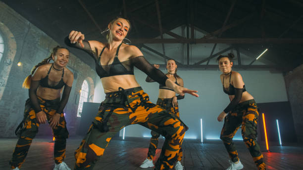 istock Female dancers practicing in studio. Modern moves, camo outfits 1298297581