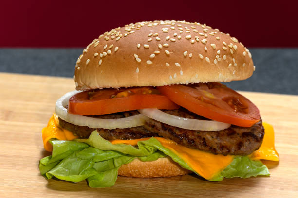 HAMBURGUER ON A WOODEN BOARD ON A BLACK AND RED BACKGROUND