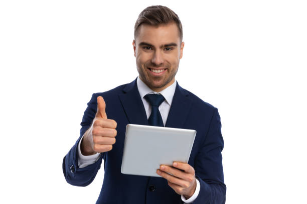 istock excited young man holding tab and making thumbs up gesture 1298303966