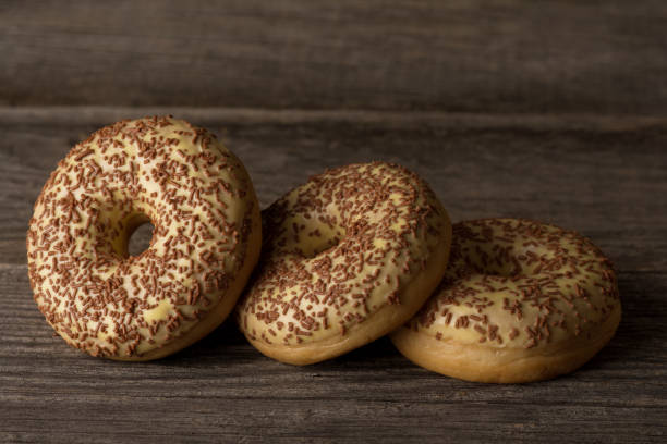 istock Delicious ring donuts covered with vanilla, topped with sprinkles. 1298305404