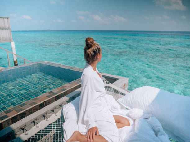 Woman relaxing in luxury hotel in the Maldives 30's woman relaxing on hammock over sea in luxury private villa in the Maldives Islands maldive islands stock pictures, royalty-free photos & images