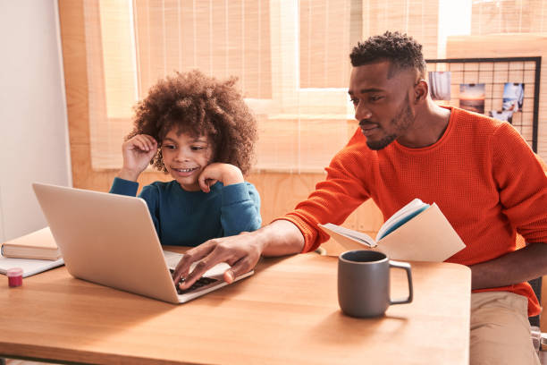 istock Boy enjoying learning with pleasant father at home 1298305651