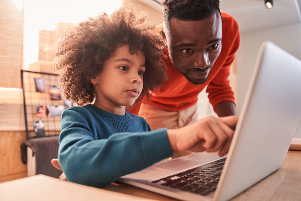 istock Boy enjoying learning with pleasant father at home 1298305667