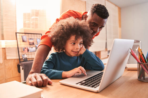 istock Man helping to son with homework at home 1298305672