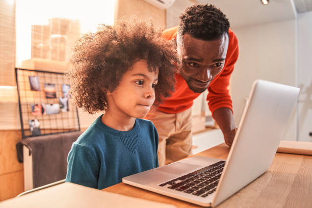 istock Man helping small child with study at home 1298305680