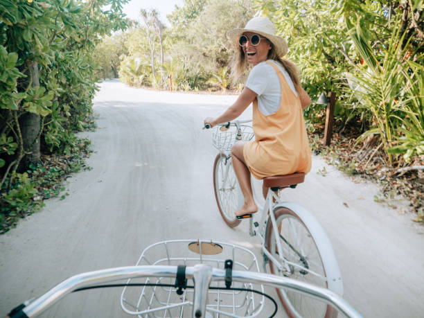 pov point of view of couple cycling on tropical island - touristic resort imagens e fotografias de stock