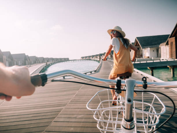 Pov point of view of couple cycling on tropical island Pov point of view of couple cycling on tropical island. Personal perspective of person cycling with girlfriend in front. Tropical luxury vacations personal perspective stock pictures, royalty-free photos & images