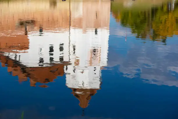 Photo of Reflection of an old castle in blue water.