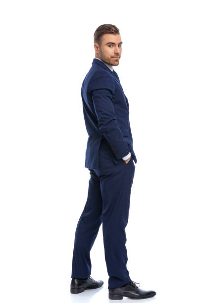 istock happy young guy in navy blue suit holding hands in pockets 1298306349
