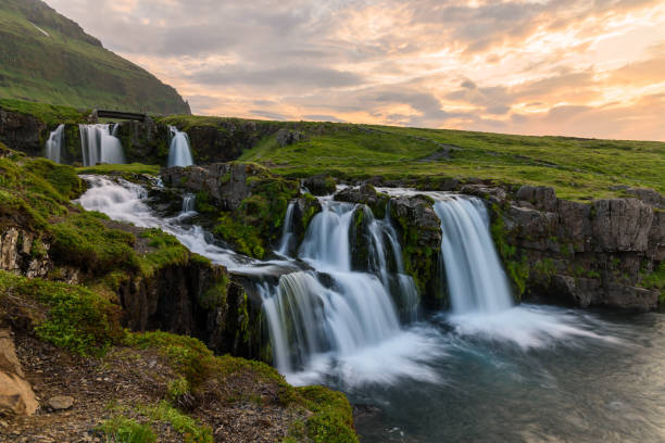 istock View of Kirkjufellsfoss waterfall lit by midnight sun in summer 1298310806