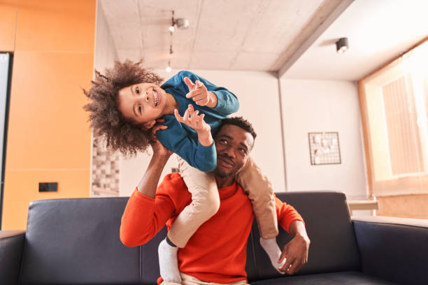 istock Father playing with his small kid boy at the sofa 1298312432