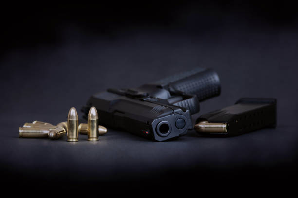 istock black pistol and cartridges on a dark background 1298314891