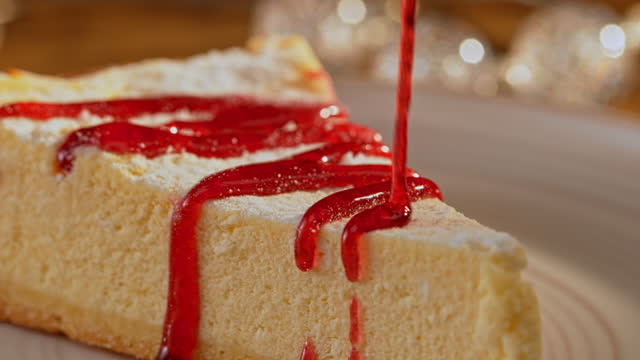 SLO MO Strawberry jam being poured over a cheesecake