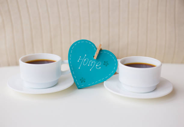 istock two cups of coffee on the table that says home 1298316224