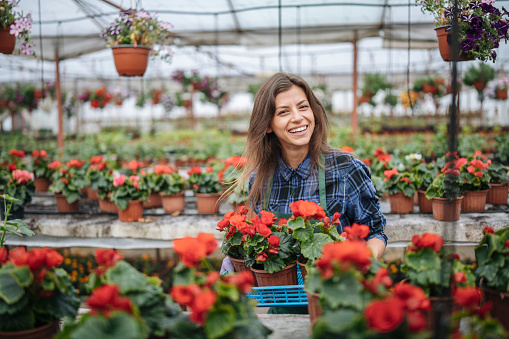 Portrait of smiling woman in flower greenhouse.