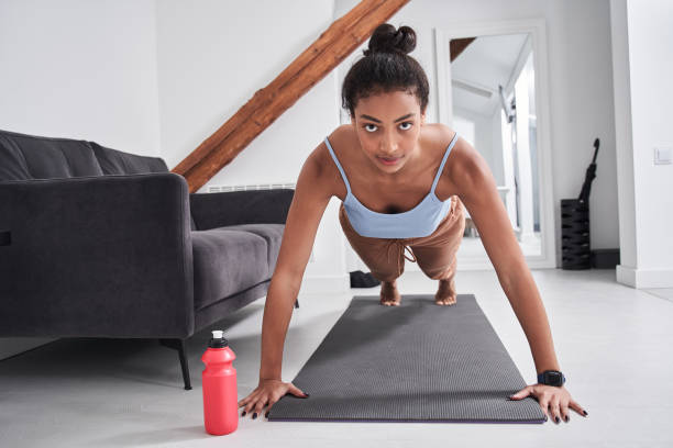 istock Woman in sportswear doing plank while standing at the mat 1298318301