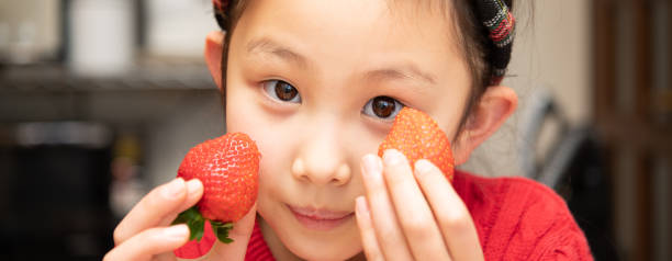istock Girl holding strawberries in both hands 1298319175