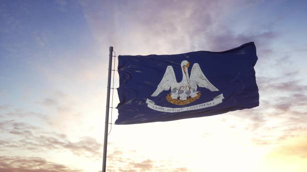 государственный флаг луизианы развевается на ветру. драматический фон неба. 3d иллюстрация - lsu стоковые фото и изображения