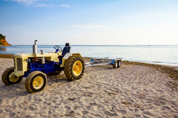 трактор с прицепом для транспортных катеров на песчаном пляже - vehicle trailer nautical vessel towing yacht стоковые фото и изображения