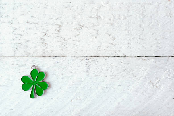 istock Green clover leaf on white wooden background with copy space 1298322213