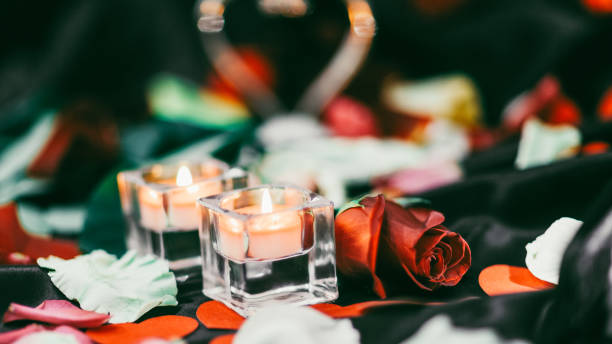 istock two candles and flower petals on a blurred festive background 1298325945