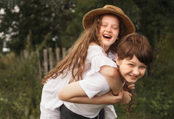 istock Happy children with piggyback riding in sunset light. 1298326349