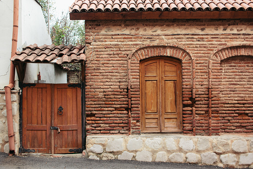 Florence, Italy - April 17, 2023: A massive wooden door to a large brick building. Two bicycles were parked against the wall of the building