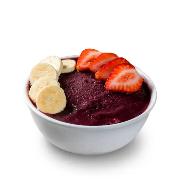 Brazilian frozen açai berry ice cream bowl with strawberries and bananas. isolated on a white background. Summer menu front view.