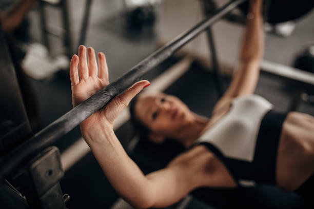 donna in forma che fa esercizio di pressa da panchina in palestra - women weight bench exercising weightlifting foto e immagini stock