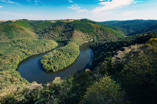 The bend in the Sioule River known as the Meandre de Queuille viewed from the Belvedere of Paradise beside the village of Queuille in the Auvergne region of France.