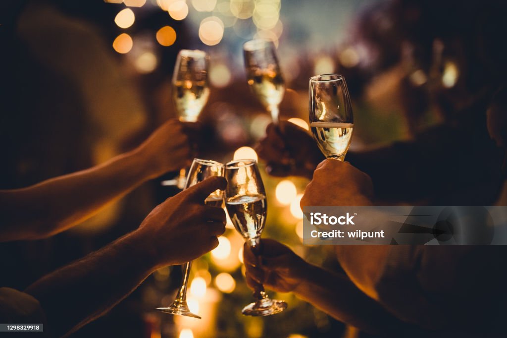 Tostadas celebratorias de cumpleaños con luces de cuerda y siluetas de champán - Foto de stock de Navidad libre de derechos