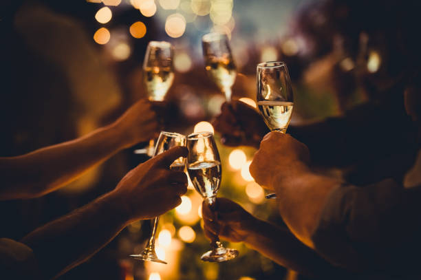 Birthday Celebratory Toast with String Lights and Champagne Silhouettes Numerous hands holding champagne flutes with champagne celebratory toast silhouettes office parties stock pictures, royalty-free photos & images