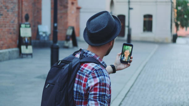 istock Back view of tourist making video call on smartphone 1298330018