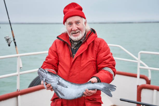 istock Fisherman showing his catch while standing at the deck 1298331709