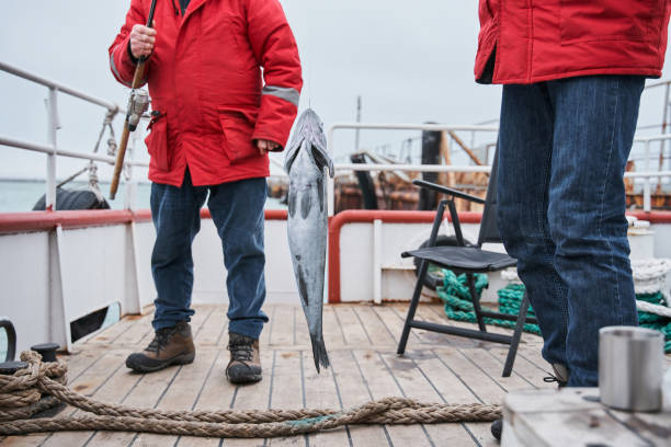 istock Fishermans holding their fish catch at the rod 1298331750