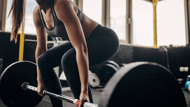 Fit woman exercising with weights in gym