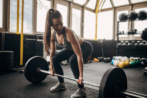 istock Fit woman exercising with weights in gym 1298333389