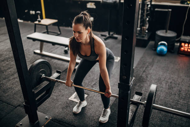 istock Fit woman exercising with weights in gym 1298333455