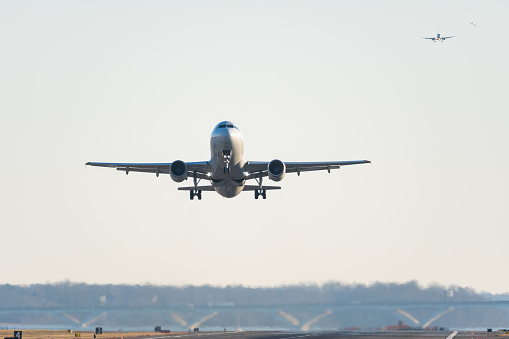 Arlington, Virginia USA- January 12th, 2020: A plane taking off from DCA with two planes on approach in the background.