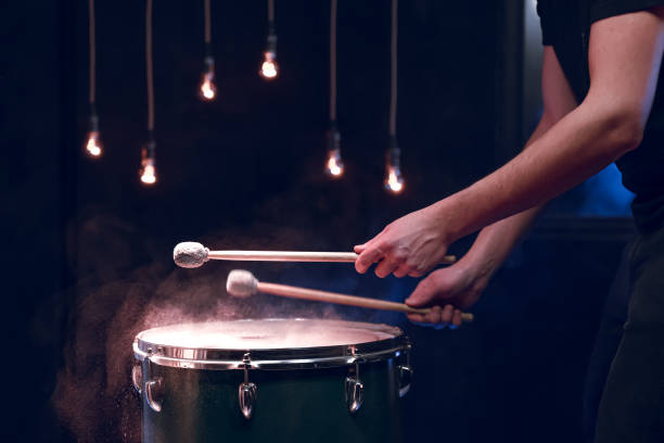 istock The drummer plays with mallets on floor tom in dark room. 1298335881