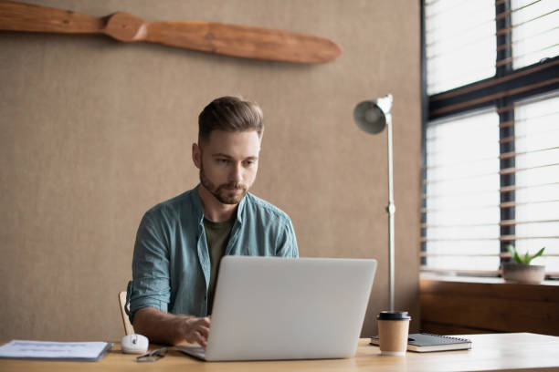 istock Businessman working on laptop computer in modern office 1298338359