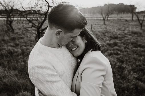 Portrait of a young couple in a field at sunset