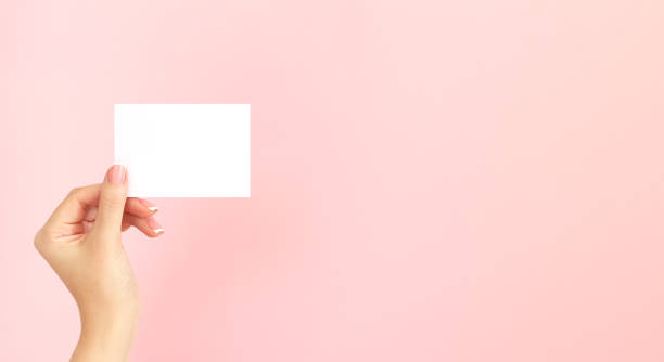 istock Woman hand holding blank white business card with copy space 1298340117