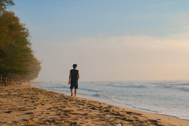 istock silhouette man walk on beach with sunrise and sea background 1298340472