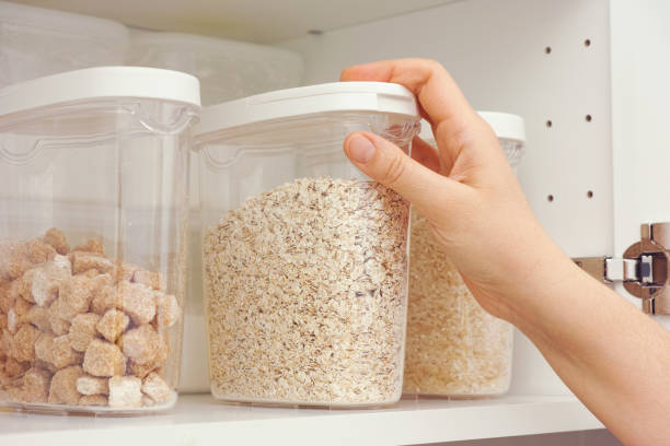 istock Woman taking oat flakes from a kitchen cupboard 1298341167