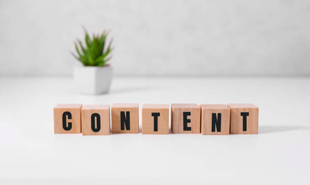 istock Content - word from wooden blocks with letters, content concept, random letters around, white background 1298342945
